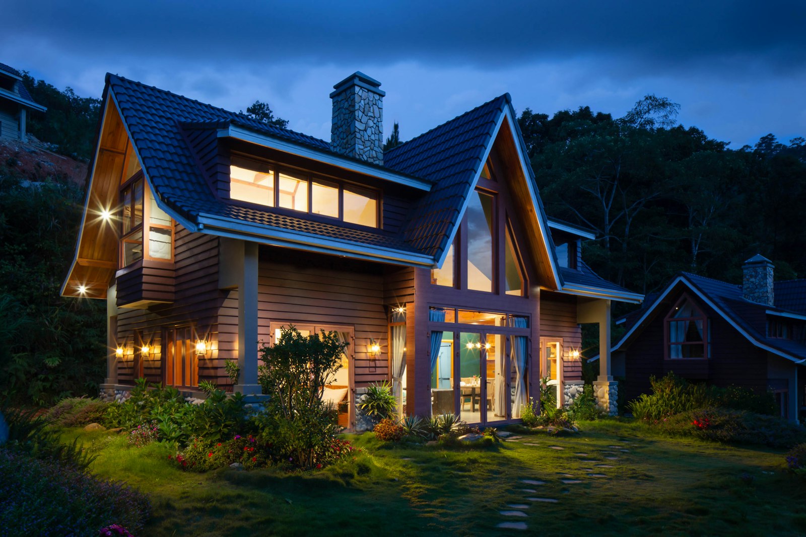 Modern single-family home at twilight, lights on inside